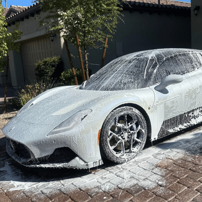 White Maserati getting cleaned in driveway